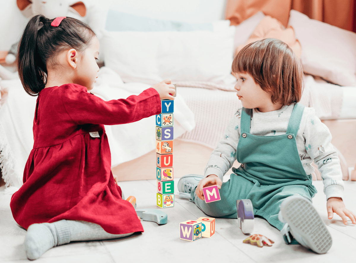Two Toddler Girls Playing with Wooden Cube Stack Puzzle